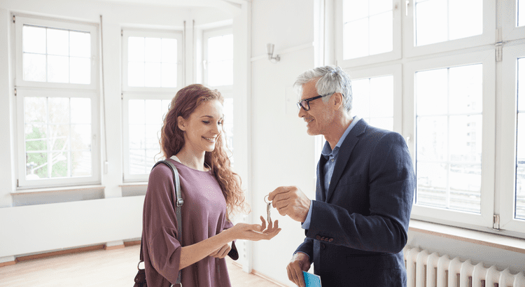 Realtor handing a woman keys to her new home